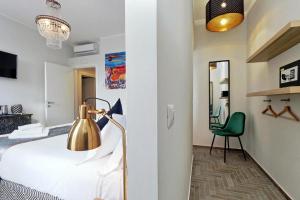 a bedroom with a bed with a lamp and a chair at Boutique Suites della Croce in Rome