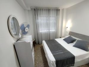 a white bedroom with a bed and a mirror at Apartment 1-1G Calle Antonion Millon in Nerja