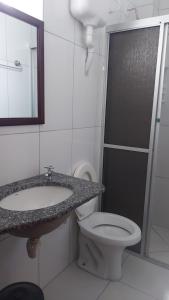 a bathroom with a sink and a toilet at Pousada Maringá in Guaratuba
