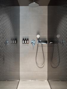 a bathroom with a shower with two shower heads at Mövenpick Zagreb in Zagreb