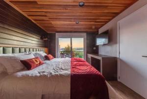 ein Schlafzimmer mit einem großen Bett und einer Holzdecke in der Unterkunft Bourbon Serra Gaúcha Divisa Resort in São Francisco de Paula