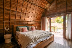 a bedroom with a bed in a wooden room at Matapalo Bungalows Uluwatu in Uluwatu