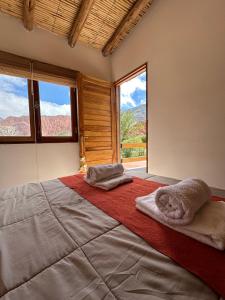 a bedroom with a large bed with towels on it at Las Lavandas Purmamarca in Purmamarca