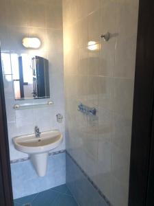 W białej łazience znajduje się umywalka i lustro. w obiekcie Villa Sun Palace w Swetim Własie