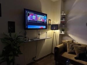 a living room with a flat screen tv on a wall at Entire One Bedroom Furnished Apartment in Islamabad