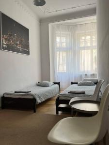 1 dormitorio con 2 camas, mesa y silla en Apart Lwowska en Varsovia