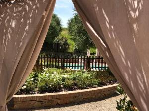 a view of a garden through the curtains of a fence at Podere Boscone in Gambassi Terme