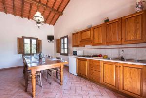 cocina con armarios de madera y mesa de madera en Podere Boscone, en Gambassi Terme