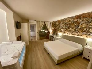 a bedroom with a bed and a stone wall at Il Tiglio Jacuzzi&Sauna in Lucca