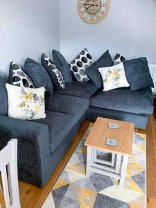 a blue couch in a living room with a table at Cosy annex in the gateway to the lakes in Burneside