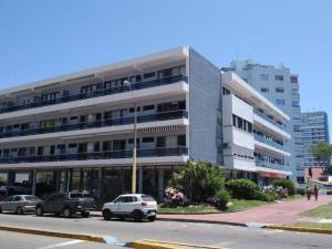 a large building with cars parked in front of it at Monoambiente Chiverta in Punta del Este