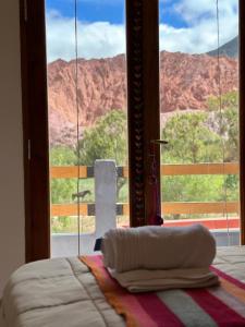 a bed in a room with a view of a mountain at Las Lavandas Purmamarca in Purmamarca