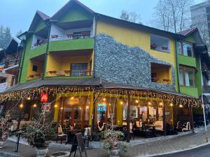 百乐·奥拉内斯蒂Pensiunea Izvoare Olanesti 3***的大楼前有圣诞灯的餐厅