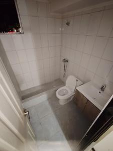 a small bathroom with a toilet and a sink at Departamento Frente al Casino Luckia 3H 2B in Arica