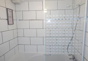 a bathroom with a shower with a tub at Mossend Apartment by Klass Living Bellshill in Mossend