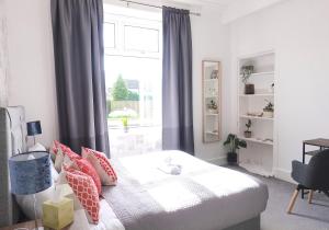 a bedroom with a bed with pillows and a window at Mossend Apartment by Klass Living Bellshill in Mossend
