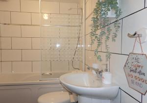 a bathroom with a sink and a toilet and a tub at Mossend Apartment by Klass Living Bellshill in Mossend