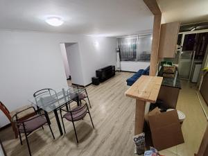 uma sala de estar com uma mesa e um sofá em Departamento Frente al Casino Luckia 3H 2B em Arica