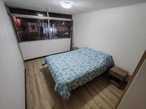 a small bedroom with a bed and a window at Departamento Frente al Casino Luckia 3H 2B in Arica