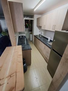 a kitchen with wooden cabinets and a counter top at Departamento Frente al Casino Luckia 3H 2B in Arica