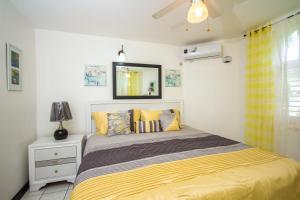 a bedroom with a bed with a yellow blanket at Ocho Rios Sandcastles Resort on the beach 1 bedroom Apartment on the Beach in Ocho Rios