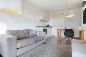 a living room with a couch and a table at Studio Deluxe 2 Pers Punt West - Land view - Ouddorp in Ouddorp