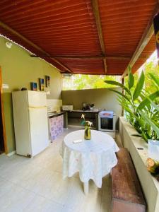 uma cozinha com uma mesa branca e um frigorífico em Caraiva Hostel em Caraíva