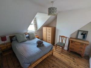 une chambre avec un lit et une chaise dedans dans l'établissement Lavender House Weymouth, à Weymouth