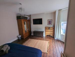 a bedroom with a bed and a tv and a wooden floor at Lavender House Weymouth in Weymouth