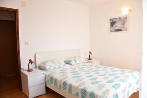 a white bed with two pillows on it in a bedroom at Family house Branka with SPA pool in Peroj