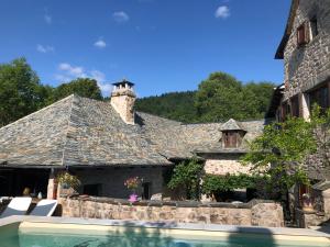 a stone house with a swimming pool in front of it at La Maison De Mon Père in Le Nayrac