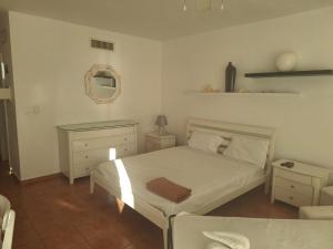 1 dormitorio con cama blanca y espejo en Vista al mar apartamento, en Juan Pedro