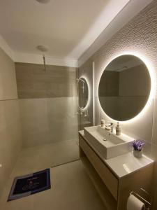 La salle de bains est pourvue d'un lavabo et d'un miroir. dans l'établissement Urban Alexa Home, à Braşov