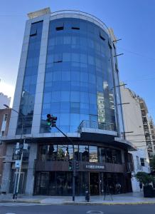 um edifício de vidro alto numa rua da cidade com um semáforo em MONS hostel em Buenos Aires
