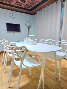 a white table and chairs in a room with a clock at macity in Incheon