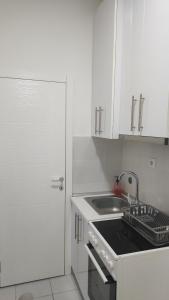 a kitchen with white cabinets and a sink and a sink at Stan na dan Loznica in Loznica