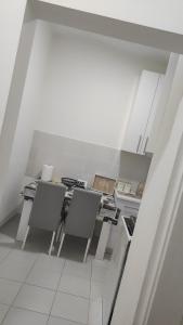 a white kitchen with a table and chairs at Stan na dan Loznica in Loznica