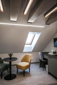 an attic office with a skylight and a table and chairs at Senamiesčio apartamentai in Anykščiai