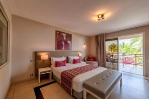 a bedroom with a large bed and a balcony at Palm Beach Resort & Spa in Ambondrona