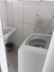 a white bathroom with a toilet and a sink at Cantinho de Iracema in Fortaleza