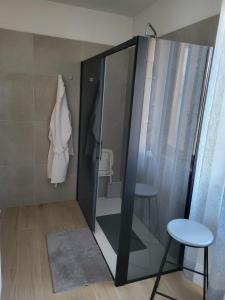 La salle de bains est pourvue d'une douche en verre avec un tabouret. dans l'établissement B&B RUFHOUSE, à Lovere