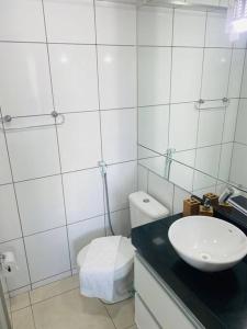 a white bathroom with a sink and a toilet at Cantinho de Iracema in Fortaleza