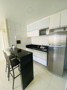 a kitchen with a table and a stove and a refrigerator at Cantinho de Iracema in Fortaleza