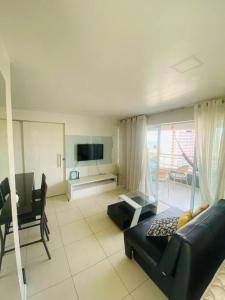 a living room with a couch and a tv at Cantinho de Iracema in Fortaleza