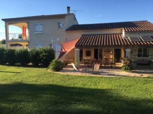 una casa grande con césped delante en Maison Blum, en Saint-Laurent-des-Arbres