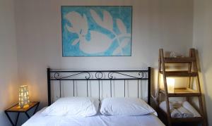 a bedroom with a bed and a painting on the wall at Arbanella in Corniglia
