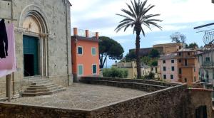 a building with a palm tree in a city at Arbanella in Corniglia