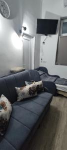sala de estar con sofá azul y cama en Apartmani DLD NS, en Novi Sad
