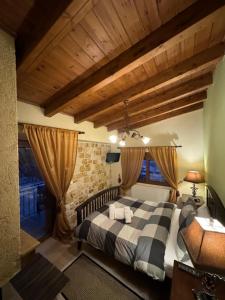 a bedroom with a large bed and wooden ceilings at Mountain View in Synikia Mesi Trikalon