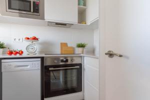 a kitchen with a stove and a microwave at Feel Welcome Barcelona in Cornellà de Llobregat